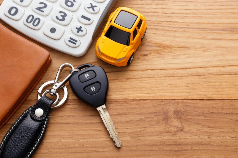 Car,Key,With,Calculator,And,Pocket,Money,On,Wood,Table